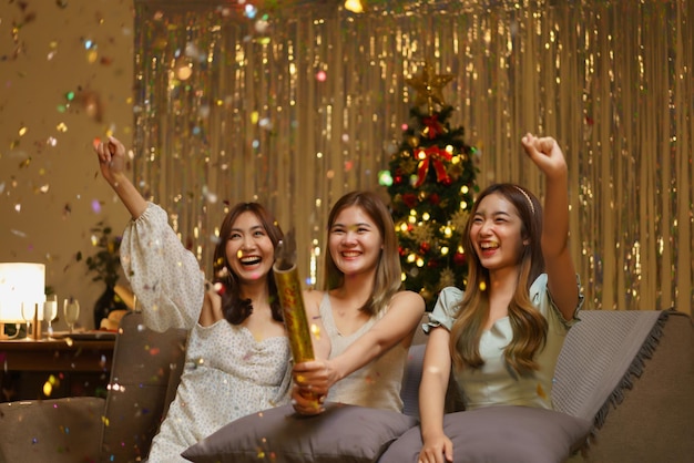 Photo new year celebration concept young beautiful group shooting confetti firework poppers with fun