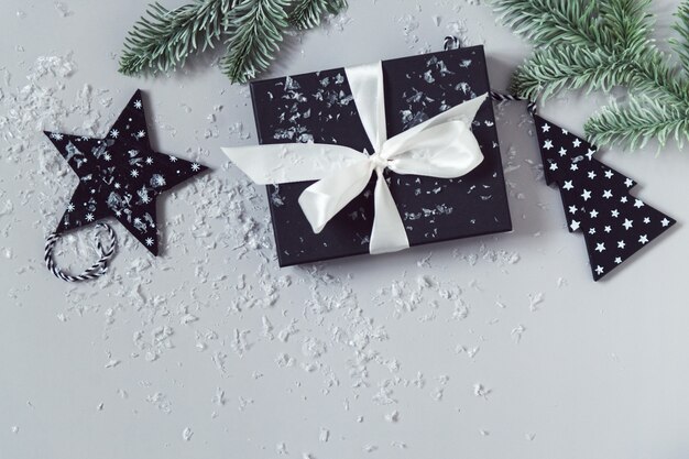 New year celebration flat lay with gift box snow and Christmas tree branches grey background