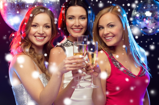 new year, celebration, friends, bachelorette party, birthday concept - three beautiful woman in evening dresses with champagne glasses