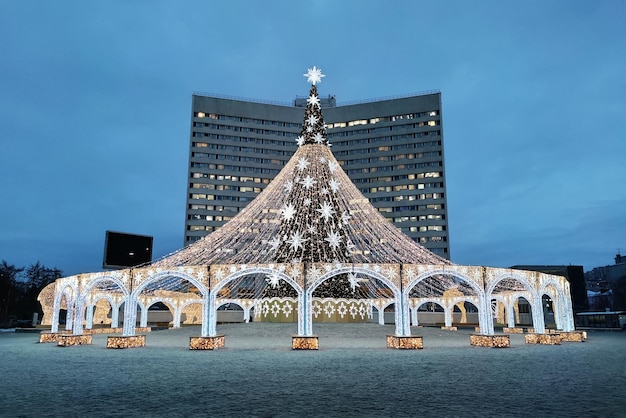 New Year celebrations View of Christmas tree against the background of tall building