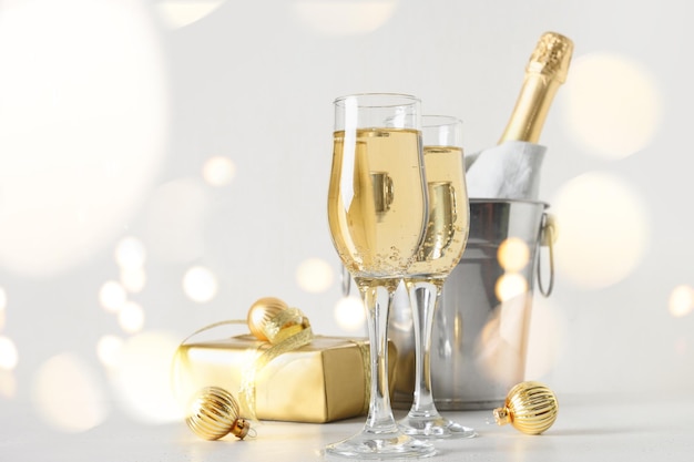 New year champagne in wine glasses and bottle in bucket decorated christmas gold baubles