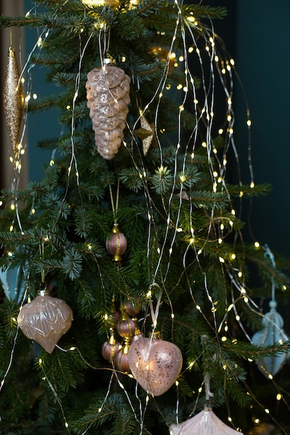 New year and christmas background with fir tree branches, garland and golden cones decor