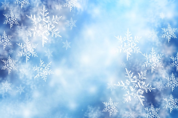 New Year and Christmas blurred snowflakes. Winter blue snow background.