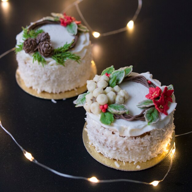 Foto torta di natale o di capodanno decorata con fiori crema stella di natale, pigne, cotone