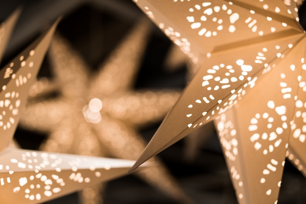 Новый год и Рождество концепция, декоративные бумажные звезды, дырявый, теплый свет в темной ночи