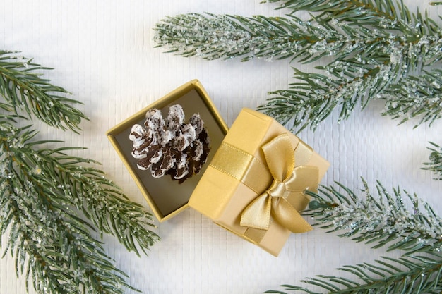 Capodanno e natale concetto di decorazioni natalizie piccola pigna decorativa di natale in confezione regalo dorata
