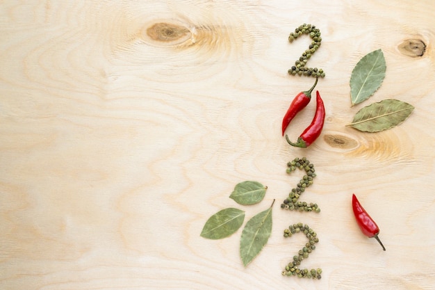 New year and christmas concept. text 2022 made of pepper on wooden background, copyspace