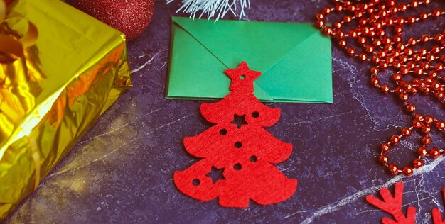 New Year and Christmas gifts. Selective focus. Santa claus hat, boxes with gifts, beads, Christmas toys on a dark background.