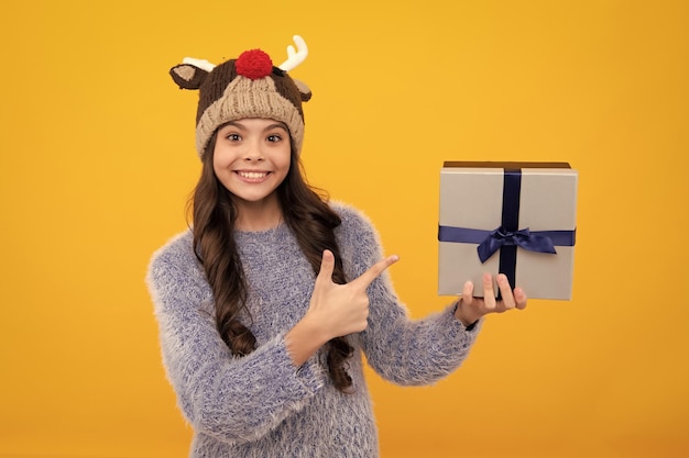 New year or christmas holiday gift happy teenager positive and smiling emotions of teen girl child with gift present box on isolated studio background gifting for kids birthday