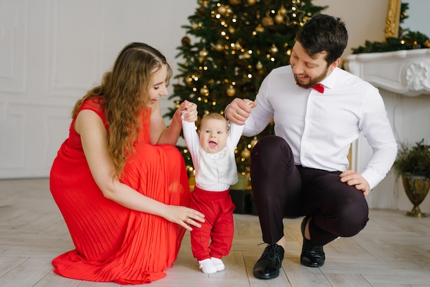 新年とクリスマスママとパパは彼らの幼い息子と手をつないでいます