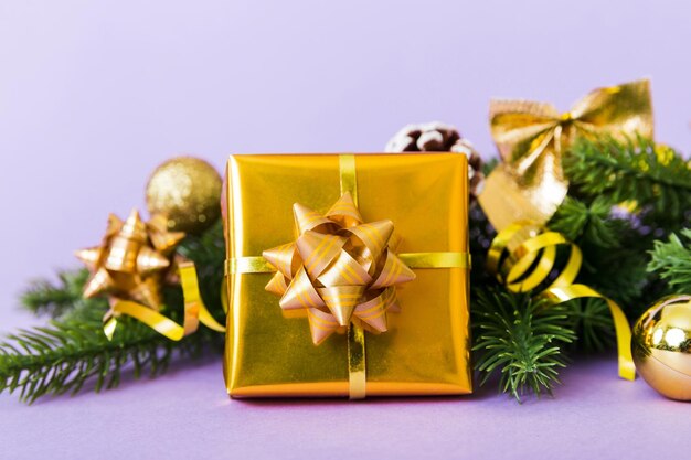 New year christmas mood gift box branches of a christmas tree new year decorations on a colored background