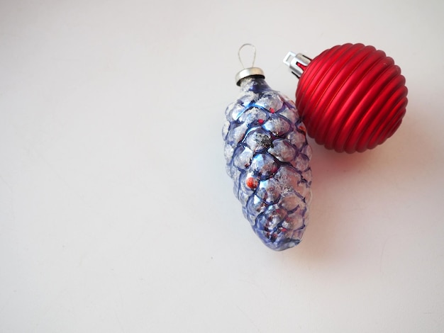 New Year and Christmas tree toys and decorations on a white background A blueviolet glass cone with decorative white snow on top Red striped Christmas ball