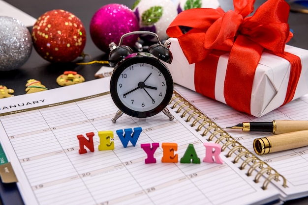 New year, clock, notepad and gift on table