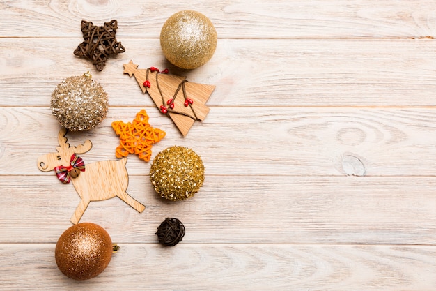 New Year composition made of baubles, reindeer and other decorations on wooden background. 