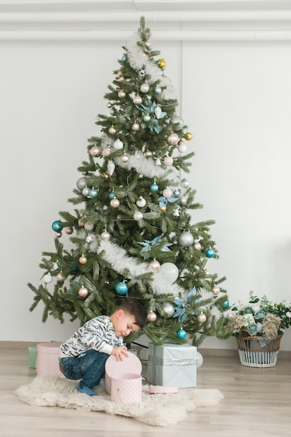 Foto concetto di nuovo anno, un ragazzo vicino a un albero di natale