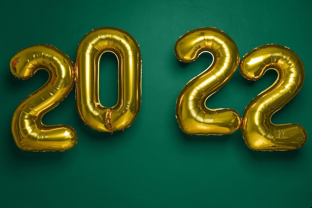 Anno nuovo concetto. palloncini gold party 2022 numeri forma su sfondo verde, panorama, spazio libero.