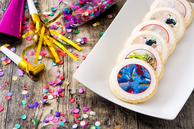 New Year cookies and confetti on wooden table