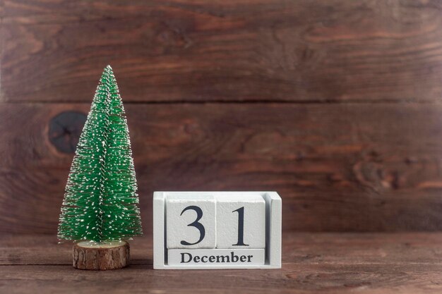 New Year. December 31st on the calendar. calendar with a small Christmas tree on a wooden background. Winter period. Empty space for text.