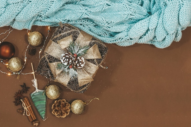 Новогодняя плоская планировка с золотым подарком, шарами, лампочками, шишками, корицей и звездой анис, карамелью с местом для текста