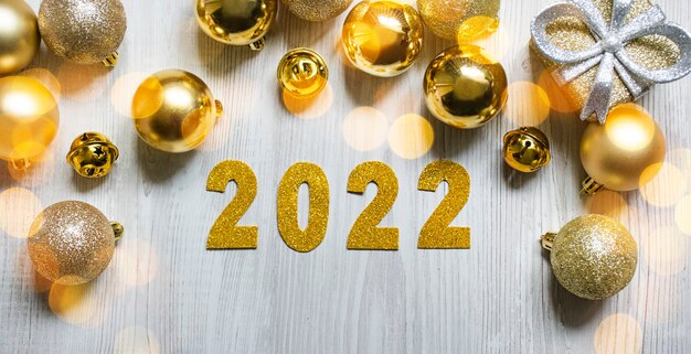 Cornice di capodanno 2022 fatta di giocattoli di capodanno su uno sfondo chiaro. bandiera del nuovo anno. composizione di capodanno. copia spazio vista dall'alto piano piano.