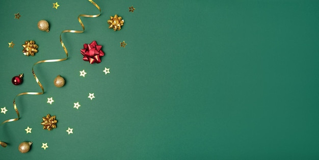 Новый год зеленый фон. Золотое украшение. Макет рождественской открытки. Блестящие безделушки.