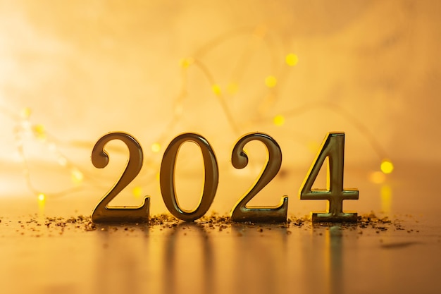写真 新年の休日の背景 黄金色の数字 2024 と明るく輝くライト