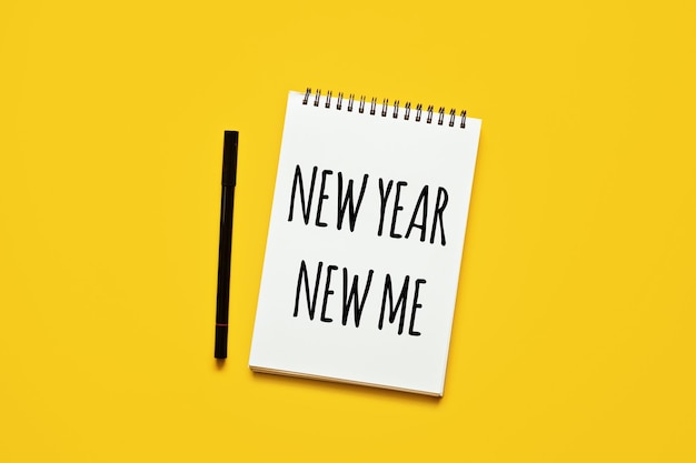 New year new me text in open notepad on yellow background setting goals and new years resolution new