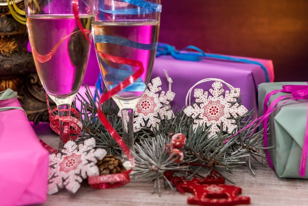 New Year postcard with champagne glasses, colorful packages and clock