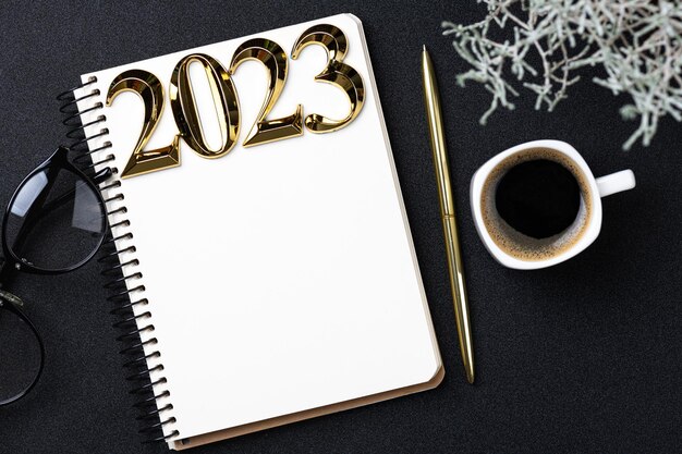 Фото Новый год резолюции 2023 на столе список резолюций 2023 с ноутбуком чашка кофе на черном фоне цели резолюции план действий контрольный список концепция новый год 2023 шаблон копировать пространство