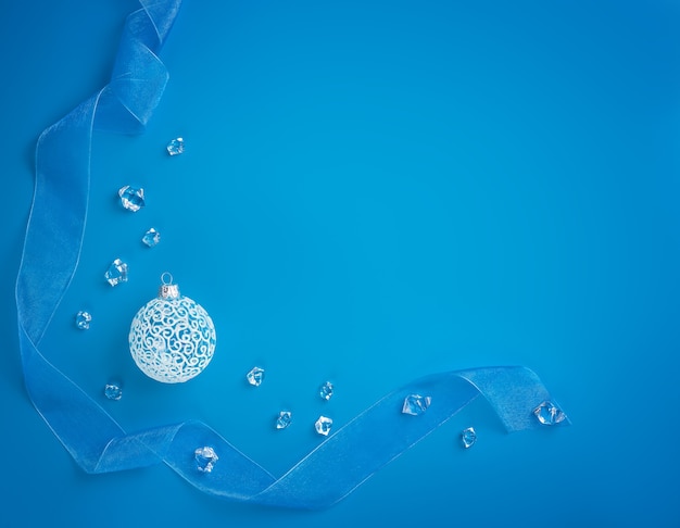 新年の背景。コピースペースと青い背景の上の白いクリスマスツリーボール
