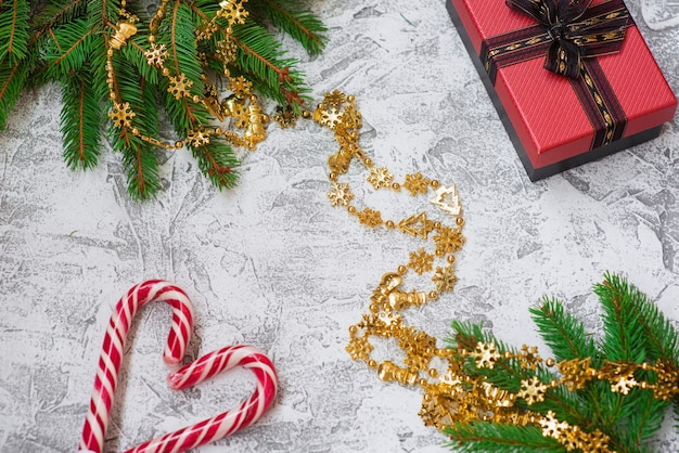 New Year's or Christmas composition of spruce green branches, New Year's garland, gift and lollipops