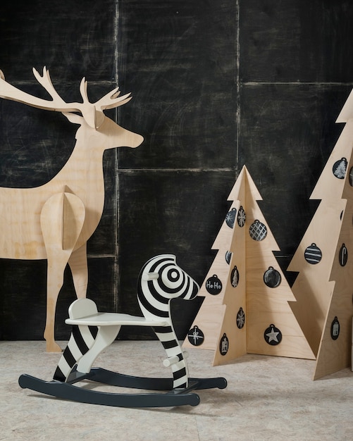 新年とクリスマスの装飾鹿とモミ合板と暗い背景の木