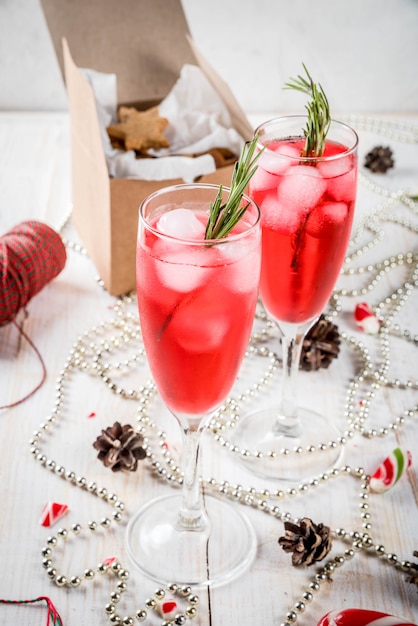 New Year's, Christmas drinks. Red alcohol cocktail with cranberry, liqueur, rosemary, with ice.