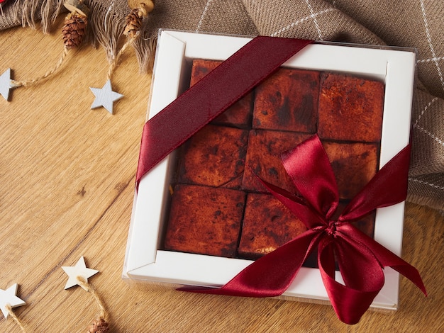 Caramella soufflé fatta a mano quadrata di still life di natale di capodanno al cioccolato su un fondo di legno