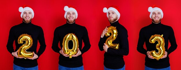 New Year's concept A man in a Santa Claus hat holds the figures of the new year 2023 the year of the rabbit according to the Chinese calendar