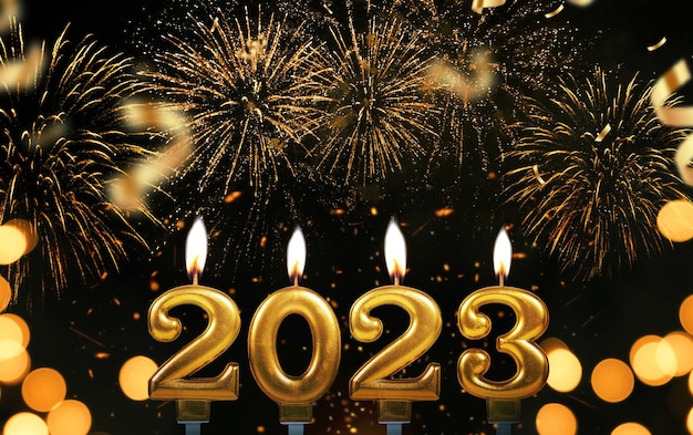 New Year's Eve 2023 Gold candles 2023 burning on a black background with fireworks and confetti Happy New Year