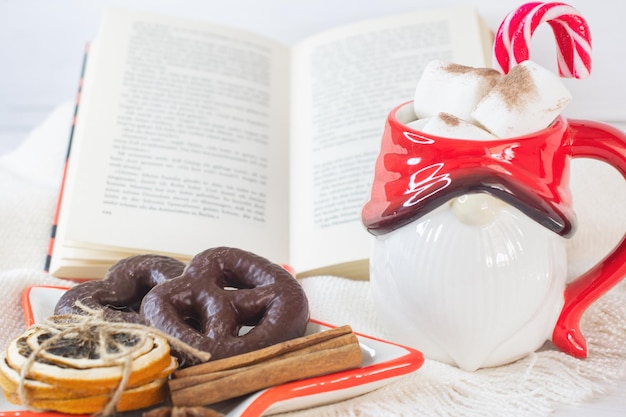 New Year's Eve background Santa Claus mug with marshmallows Christmas cookies open book