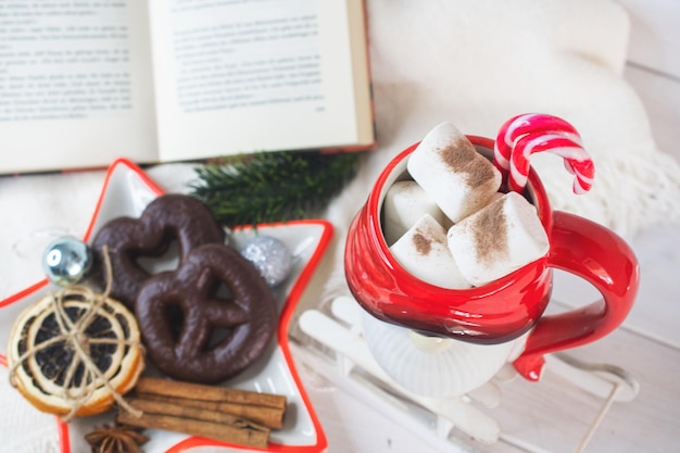 New Year's Eve background Santa Claus mug with marshmallows Christmas cookies open book