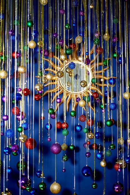 Новогодняя гирлянда из шаров и дождь на синей стене Яркие праздничные краскиПразднование нового года