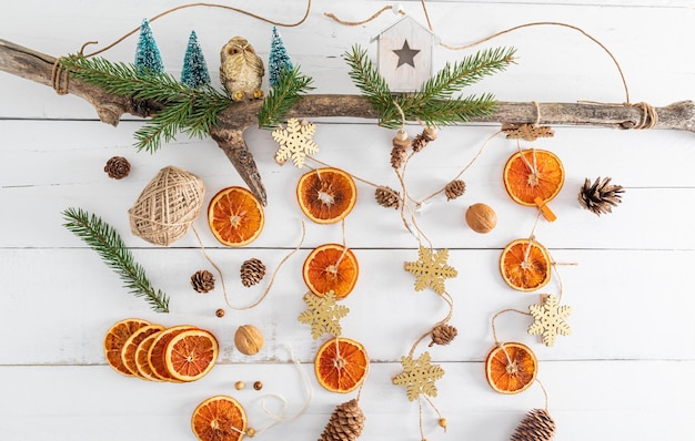 New Year's garland handmade from natural organic dried oranges cones on a wooden tree trunk top view