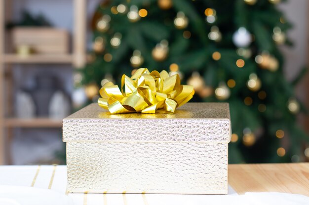 Regalo di capodanno sullo sfondo di un albero di natale. capodanno e natale. regali per le vacanze. atmosfera festosa. un albero di natale. bokeh. copia spazio