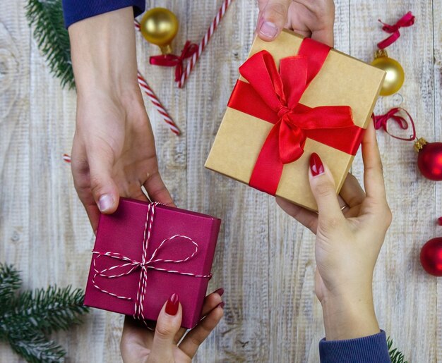 New Year's gifts in hands on a wooden background. Christmas selective focus