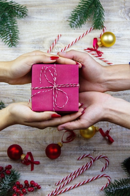 New Year's gifts in hands on a wooden background. Christmas