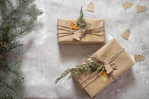 New Year's gifts packed in craft paper lie on a roofing sheet on a gray background