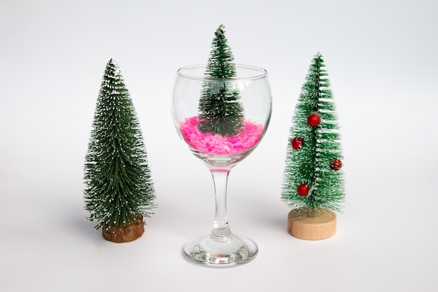New Year's green Christmas tree in a wine glass red gift boxes. Christmas Greeting Card