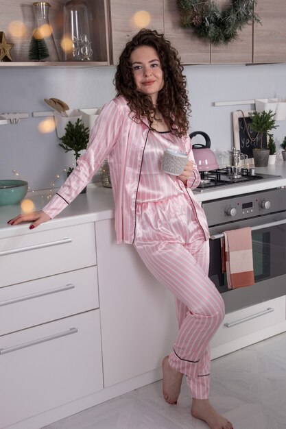 New year's kitchen decoration. christmas table setting a girl drinks tea in a festive kitchen