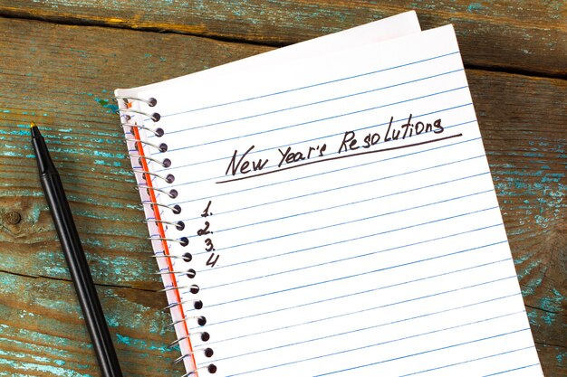 New year's resolutie geschreven op een notitieblok en een pen. nieuwjaar resoluties concept.