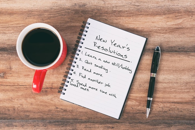 New Year's resoluties Concept notitieblok pen en kopje koffie achtergrond