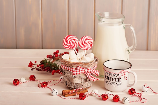 New Year's sweets marshmallows, lollipops and milk on the table with gifts