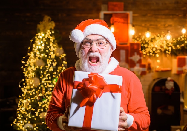 New year santa claus with big present box man in santa costume with christmas gift christmas santa